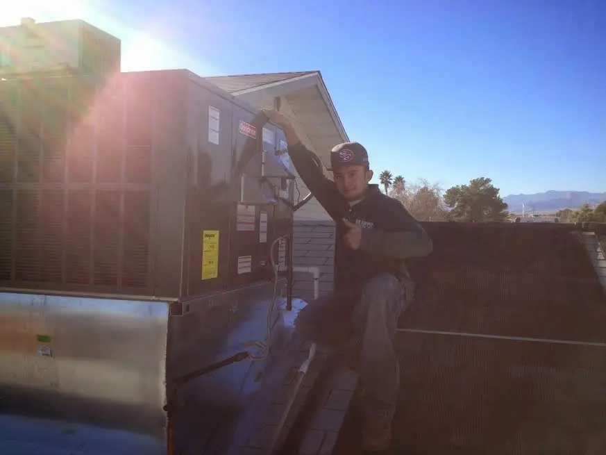 HVAC technician performing Heat Pump Repair on a rooftop unit in La Junta